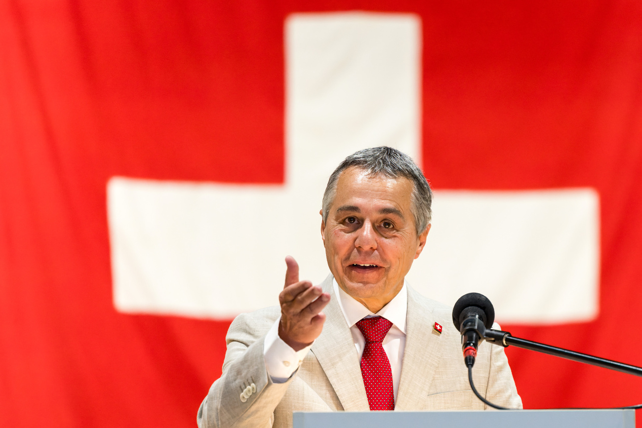 Ognazio Cassis davanti a una bandiera svizzera