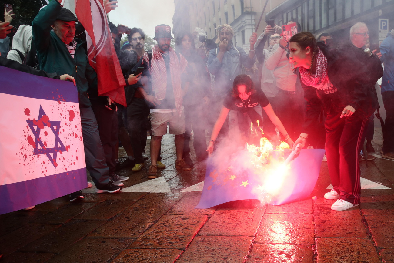 Una bandiera israeliana viene bruciata durante una manifestazione a Milano.