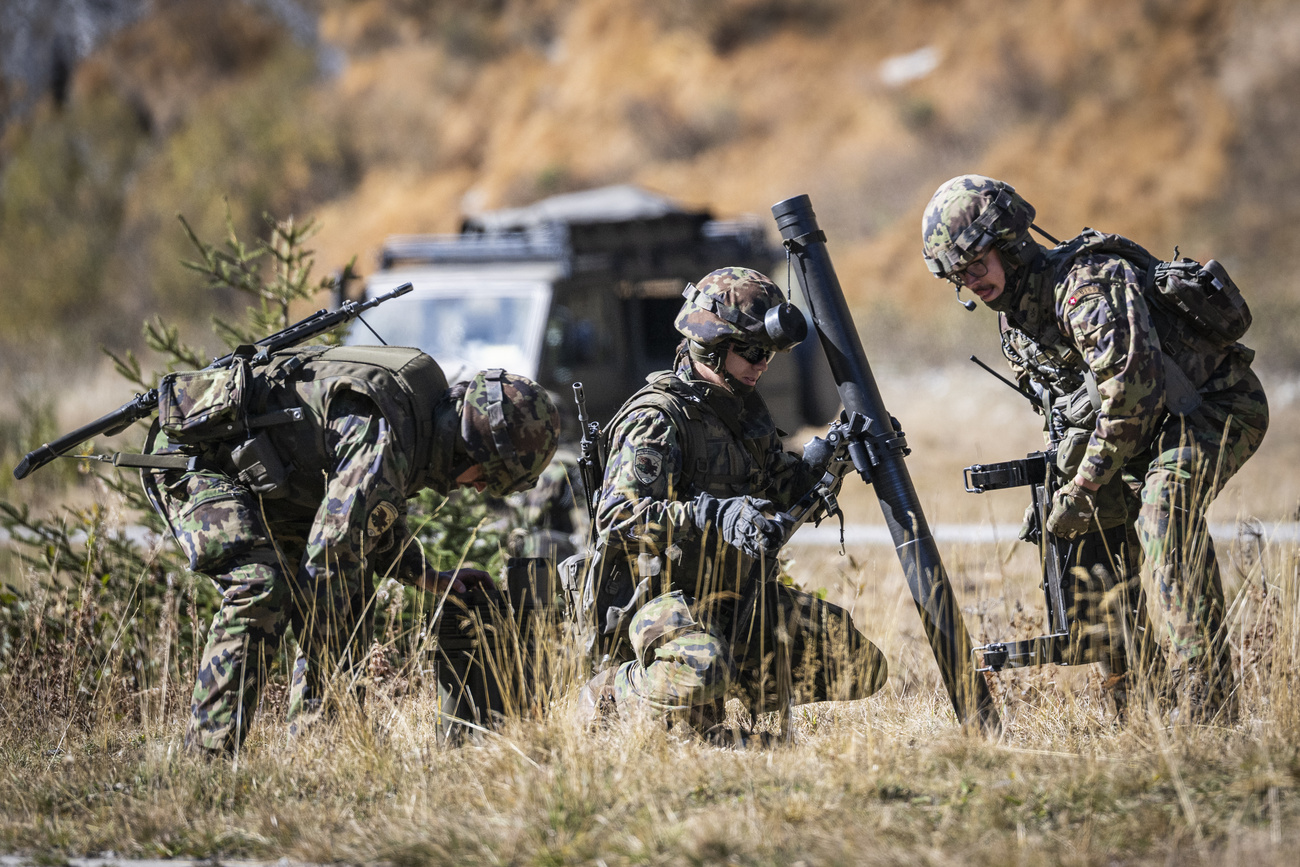 Swiss Army soldiers during a combat exercise with a mortar at the Hinterrhein military training area.