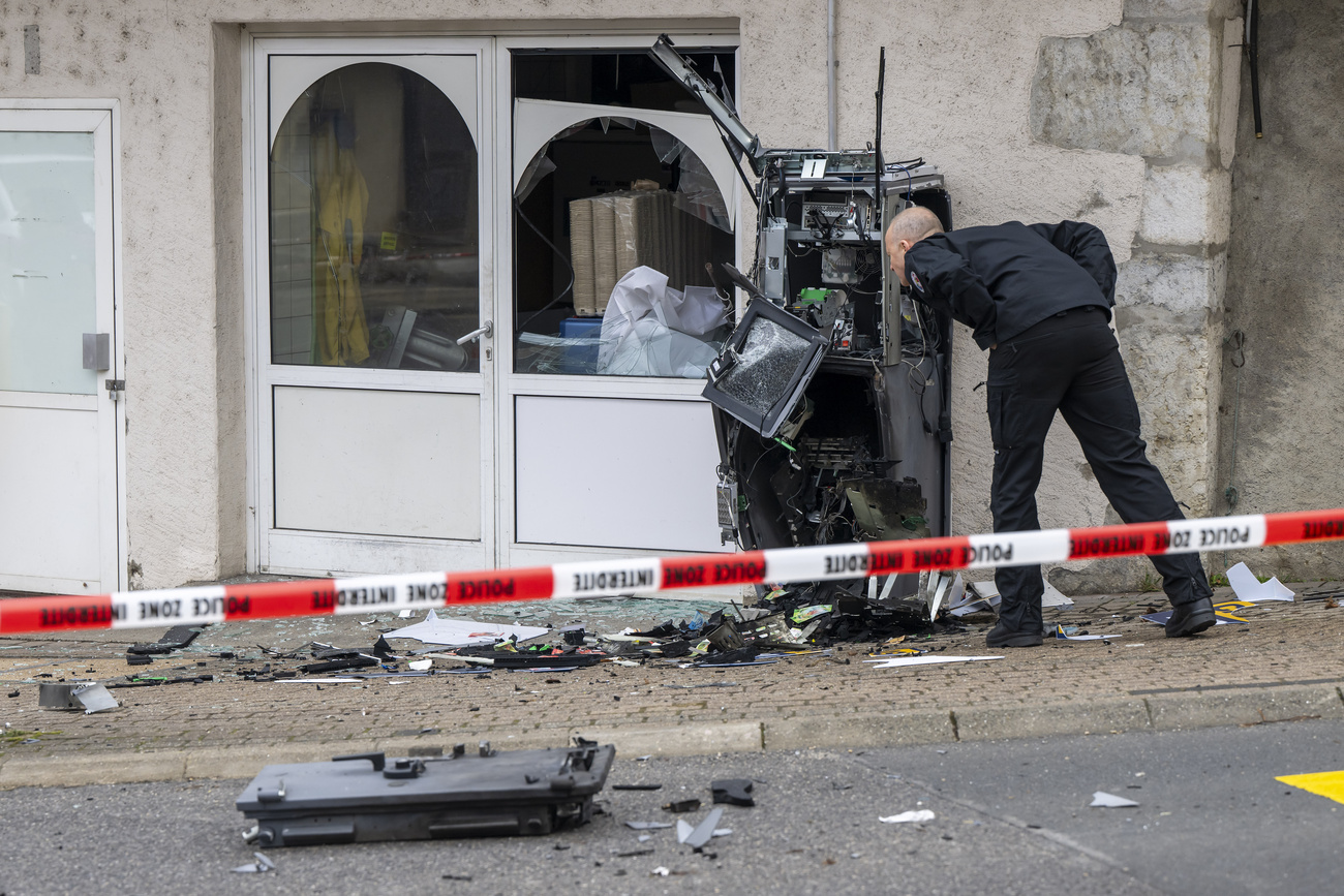 un agente dell'Ufficio federale di polizia (fedpol) esamina un bancomat fatto esplodere