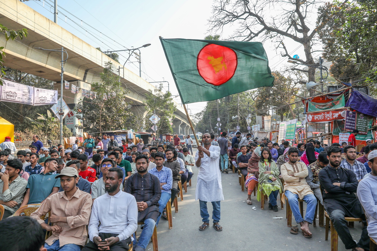 man carrying a green and red flag at a rally