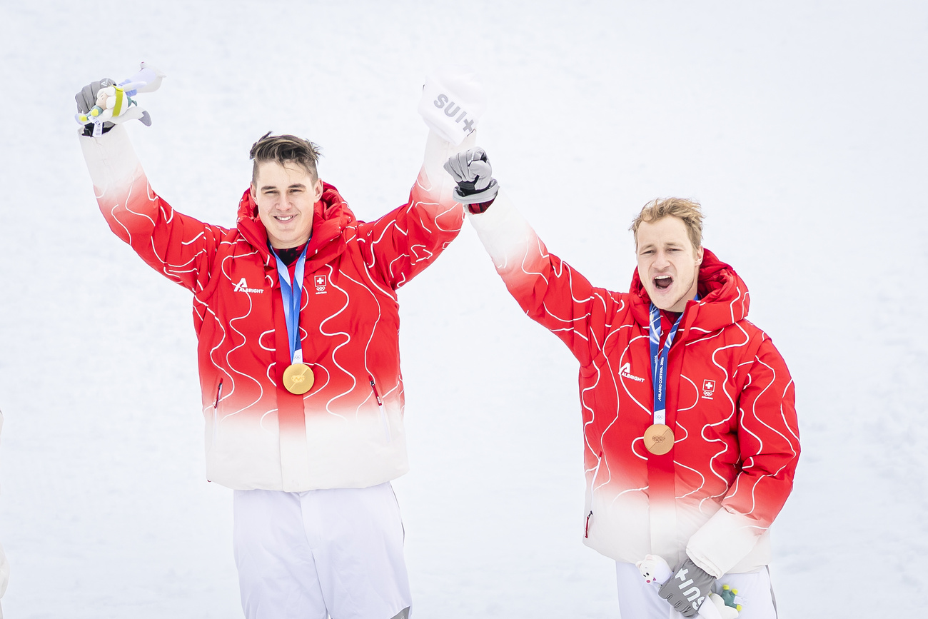 Photo of two men with gold and bronze medals at Winter Olympics.