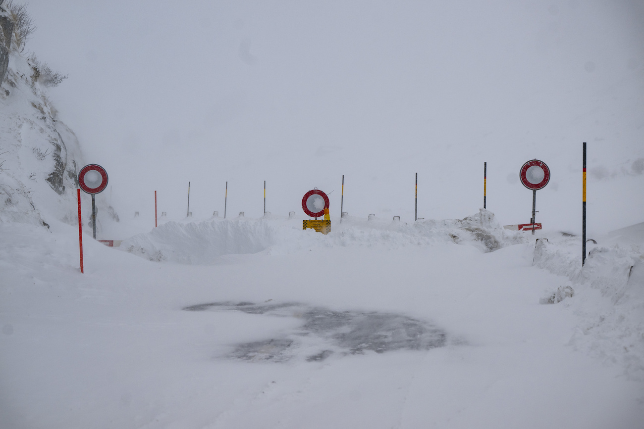 strada coperta di neve con cartelli di divieto di accesso