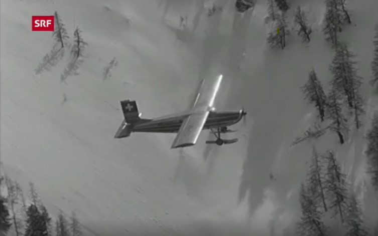 Flugzeug über den Alpen wirft Heu ab