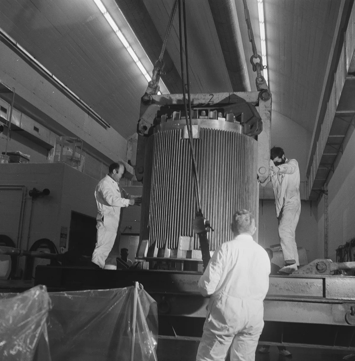 Drei Techniker um einen Kernreaktor herum (historisch)