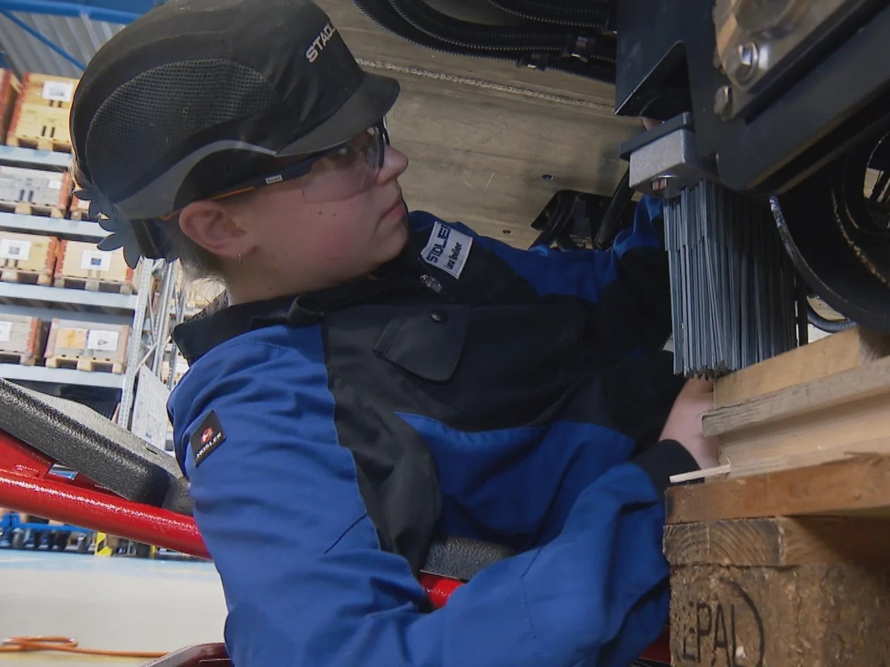 Lena Gähwiler, a second-year apprentice, is working on the bogie under the tram.