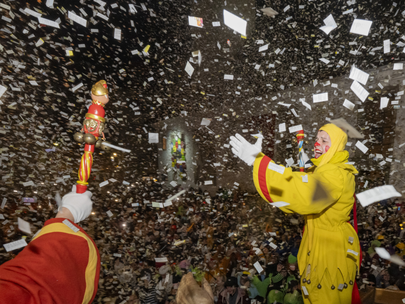 persone in maschera sotto una pioggia di coriandoli