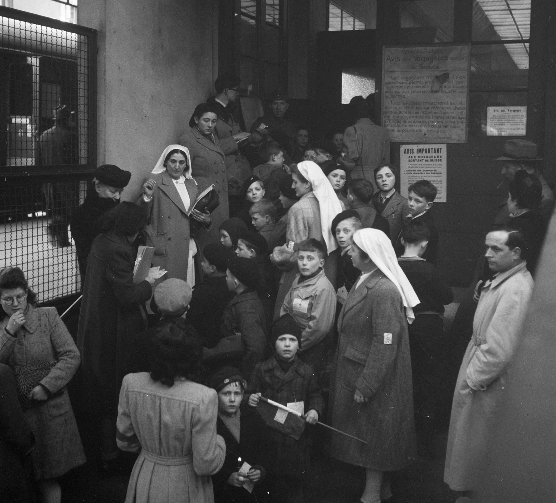 Ordensschwestern und viele Flüchtlingskinder an einem Bahnhof im Jahr 1942