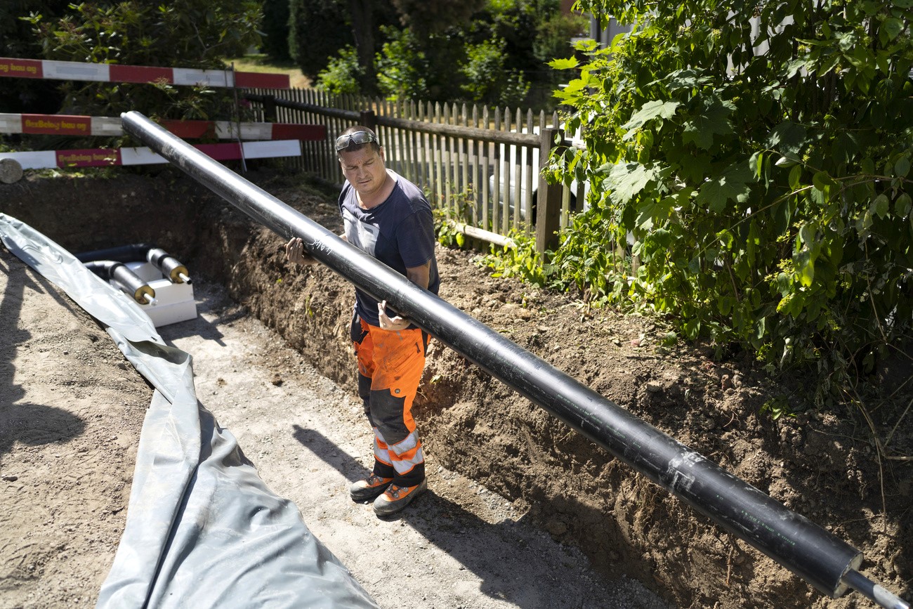 un operaio posa una condotta nel terreno