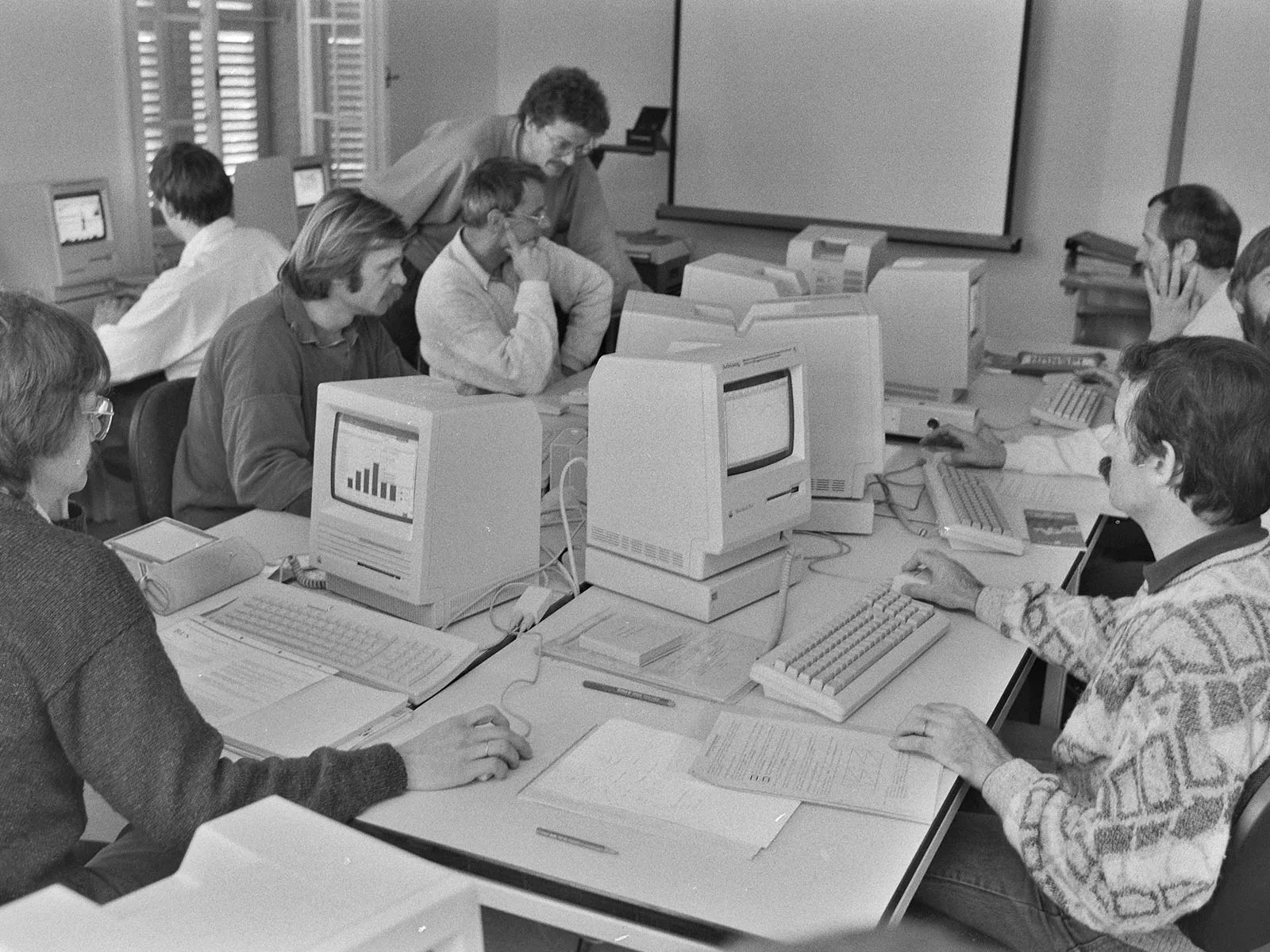 Mehrere Personen an Computern (historisch)
