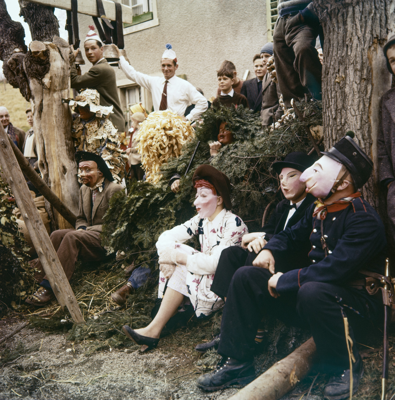 People in fancy dress are sitting on fir branches