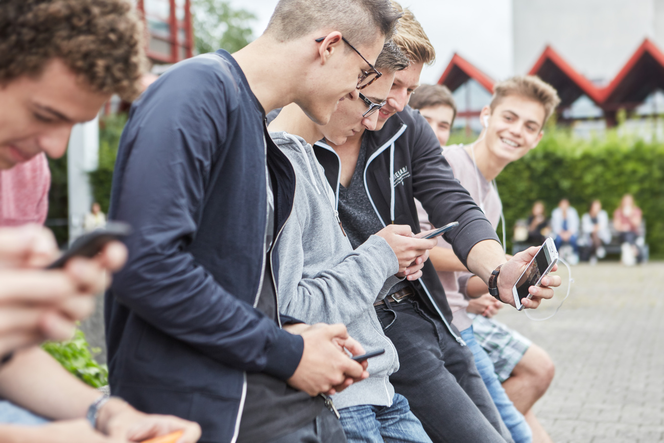 Jungs auf dem Pausenplatz am Smartphone