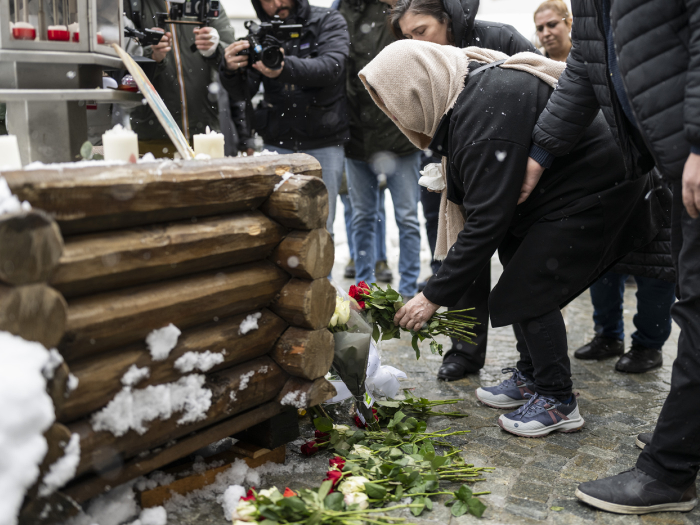Una persona deposita dei fiorni vicino al Le Constelaltion di Crans-Montana.