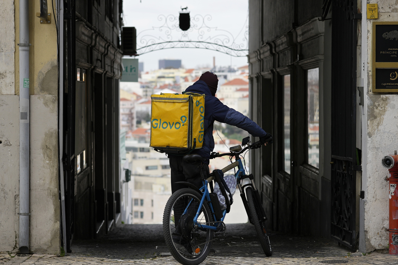 rider glovo in piedi accanto alal sua bici