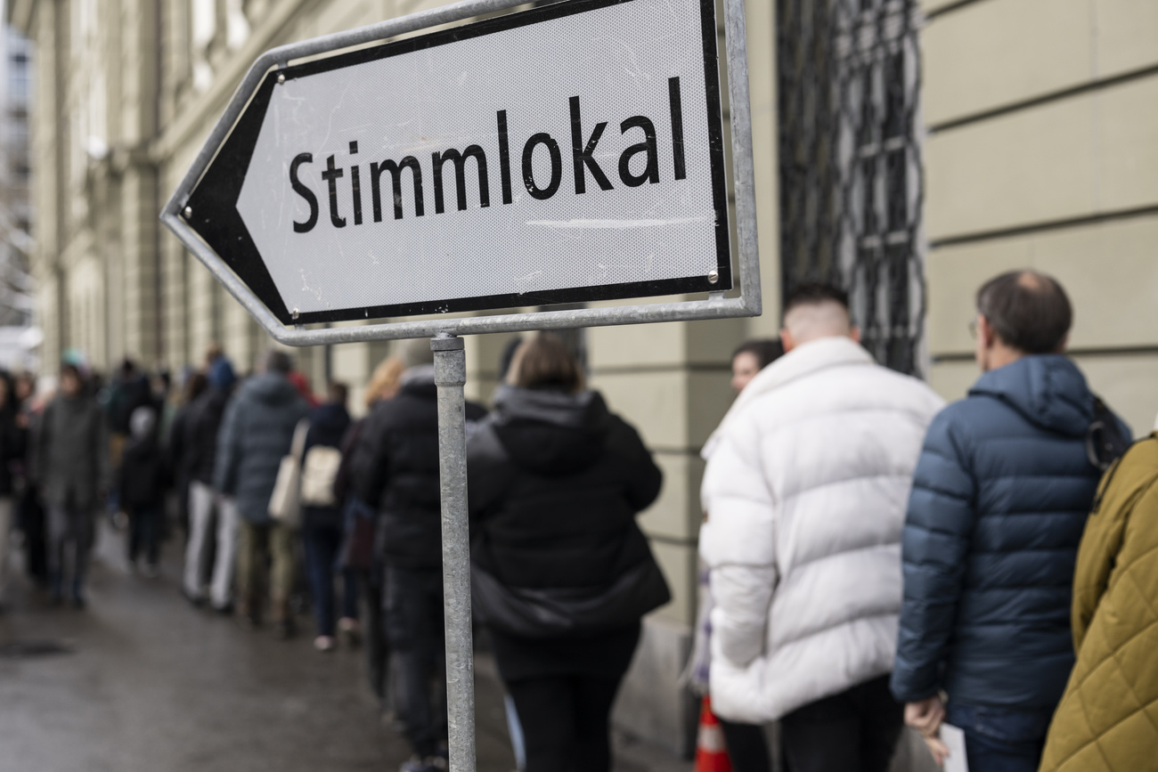 Persone in fila davanti a locale di voto