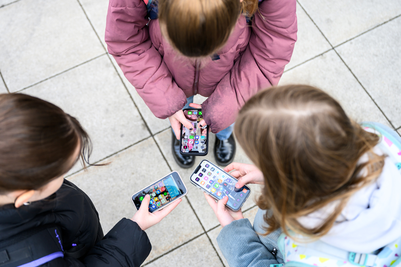 Três crianças com celulares