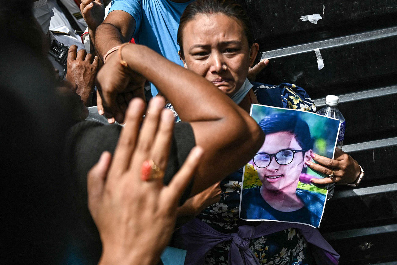 Une femme tient un portrait d'un membre de sa famille, décédé lors d'affrontements avec les forces de sécurité