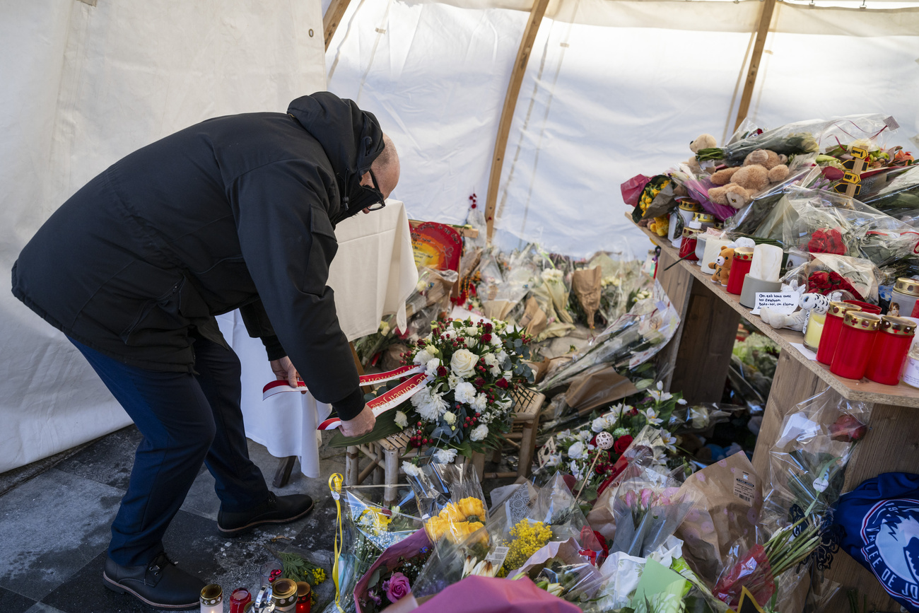 A person laying flowers at Le Constellation bar in Crans-Montana