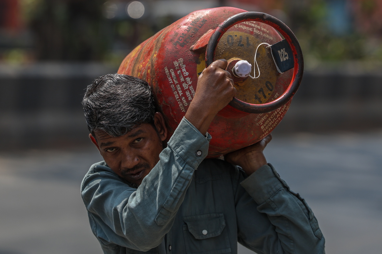 رجل هندي يحمل أسطوانات غاز فارغة في مومباي وسط نقص في الإمدادات بسبب اضطرابات سلاسل التوريد المرتبطة بحرب الشرق الأوسط.