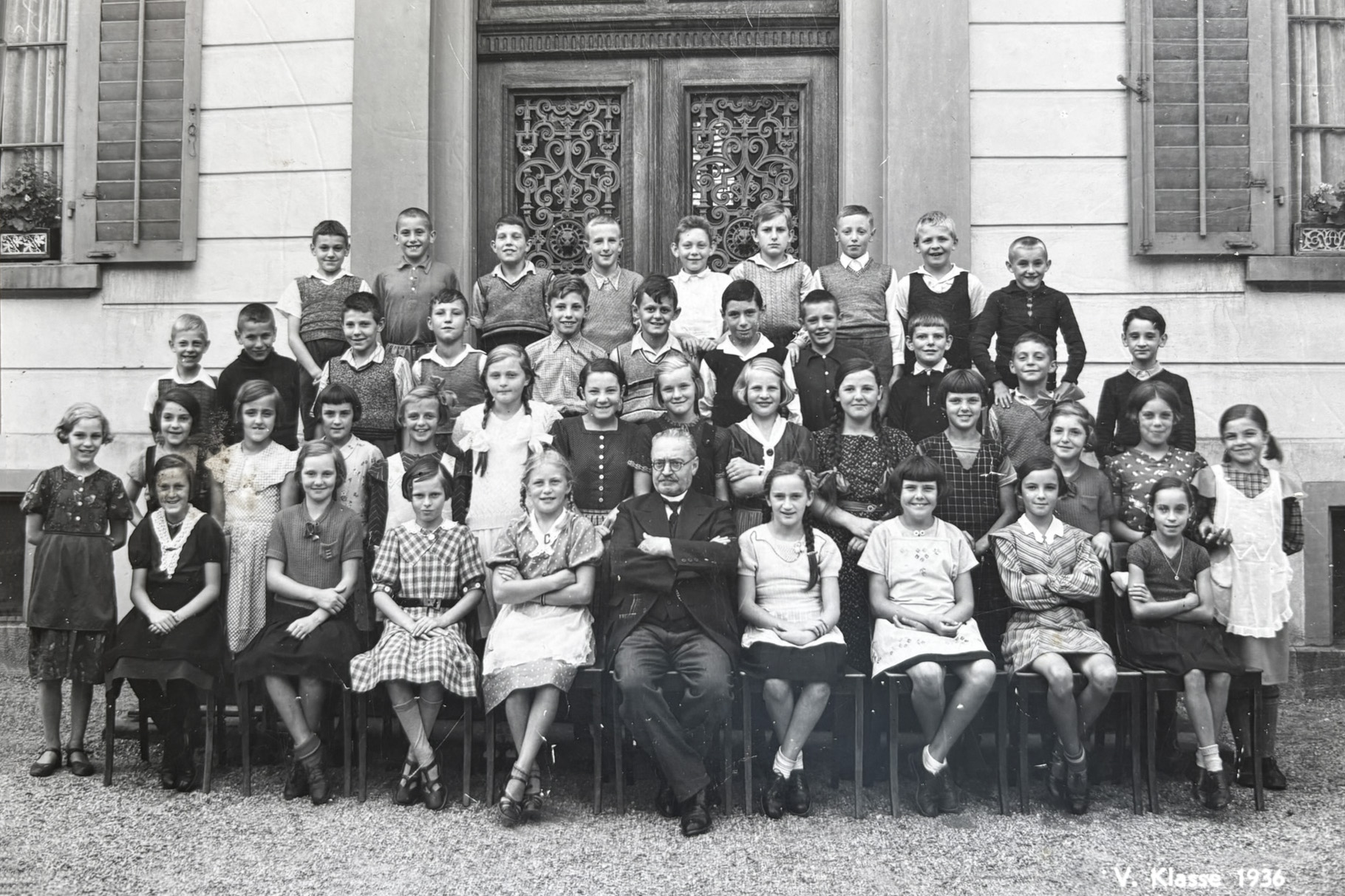 Class photo taken in Glarus in 1938, 4 rows of pupils and their teacher in the middle.