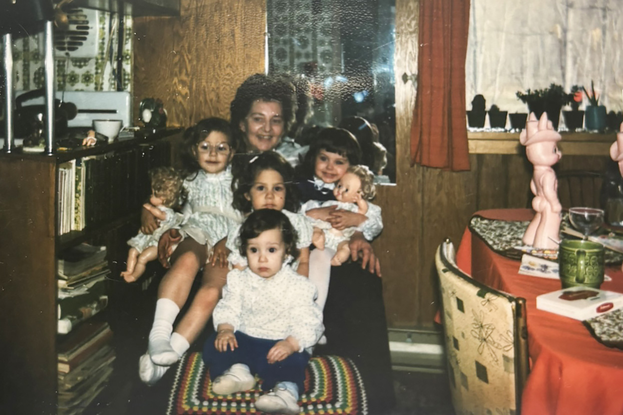 Four children sitting on their grandmother's lap.