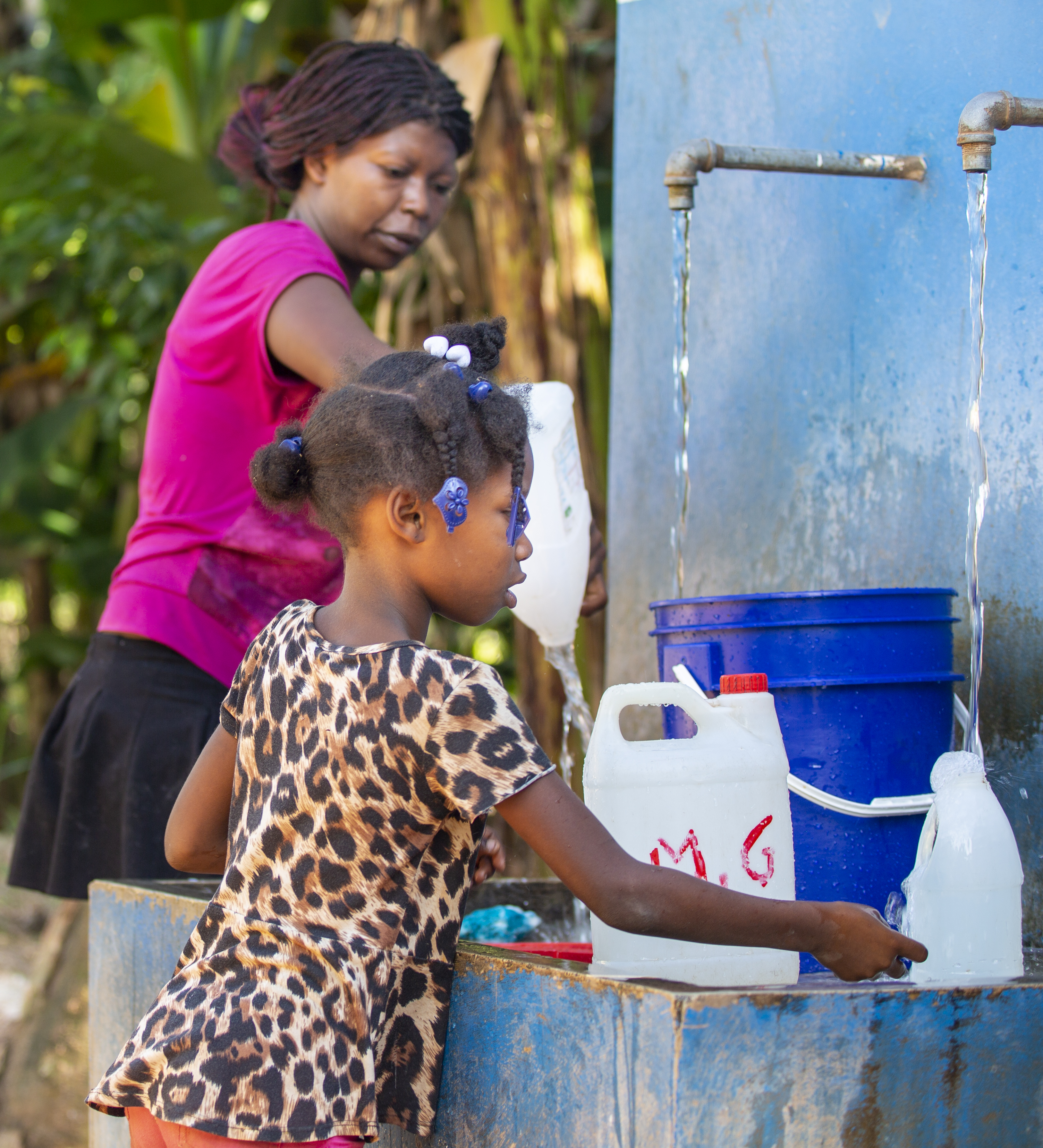 Woman and girl at water pump. Water sanitation programme, Helvetas