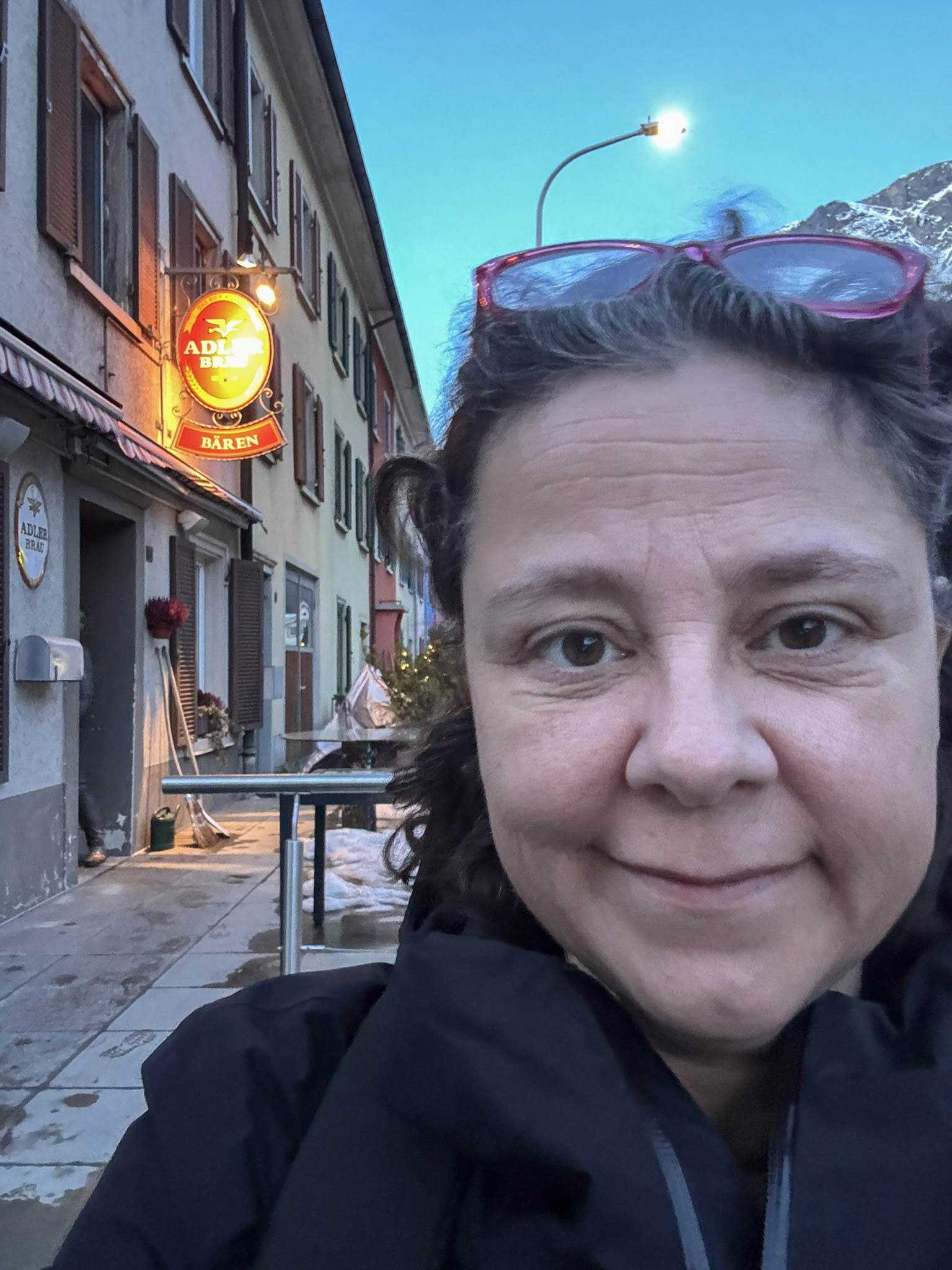 Selfie picture of a woman standing in front of the entrance of a bar.