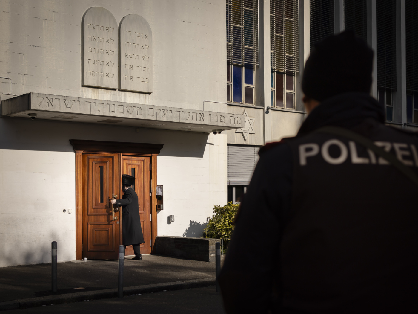 poliziotto osserva l'entrata di una sinagoga