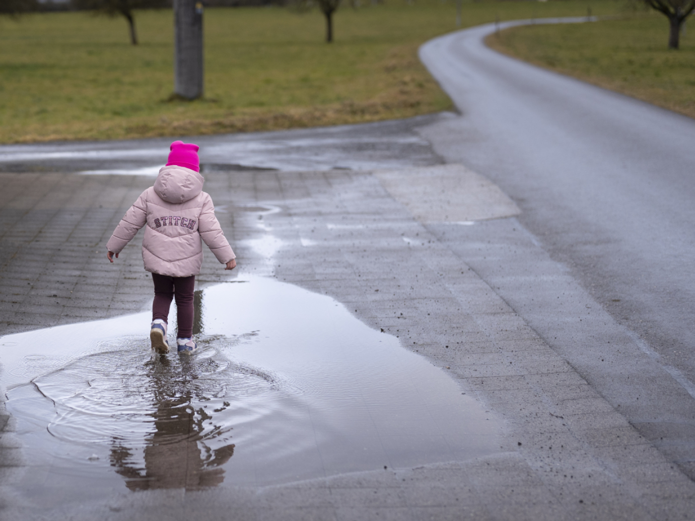 bambina gioca in una pozzanghera