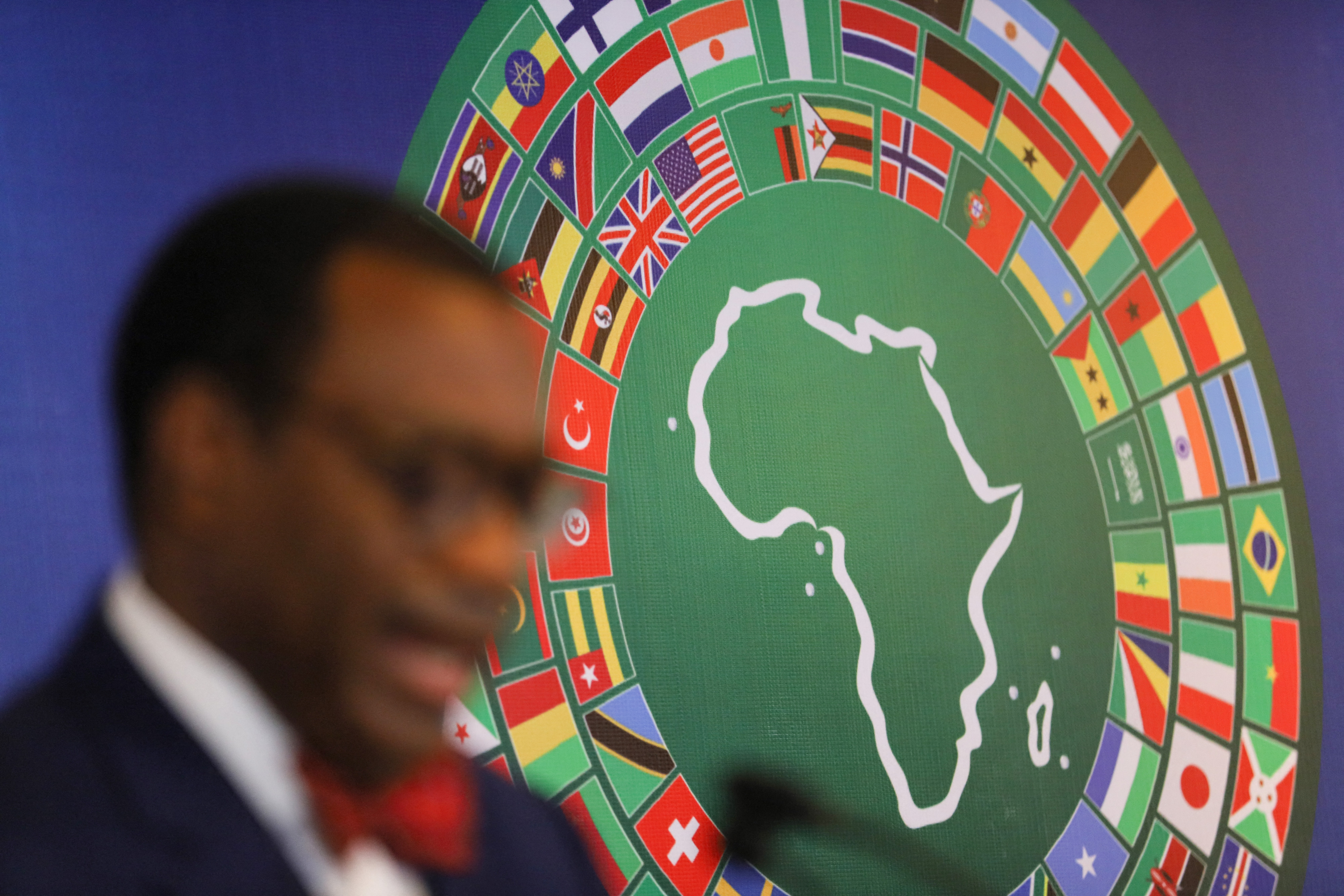 Un homme devant une affiche représentant l'Afrique