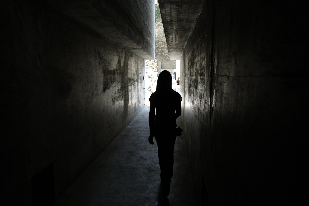 Ragazza in controluce in un passaggio buio.