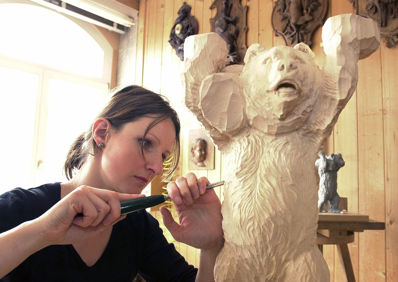 ragazza intaglia statua di legno di un orso