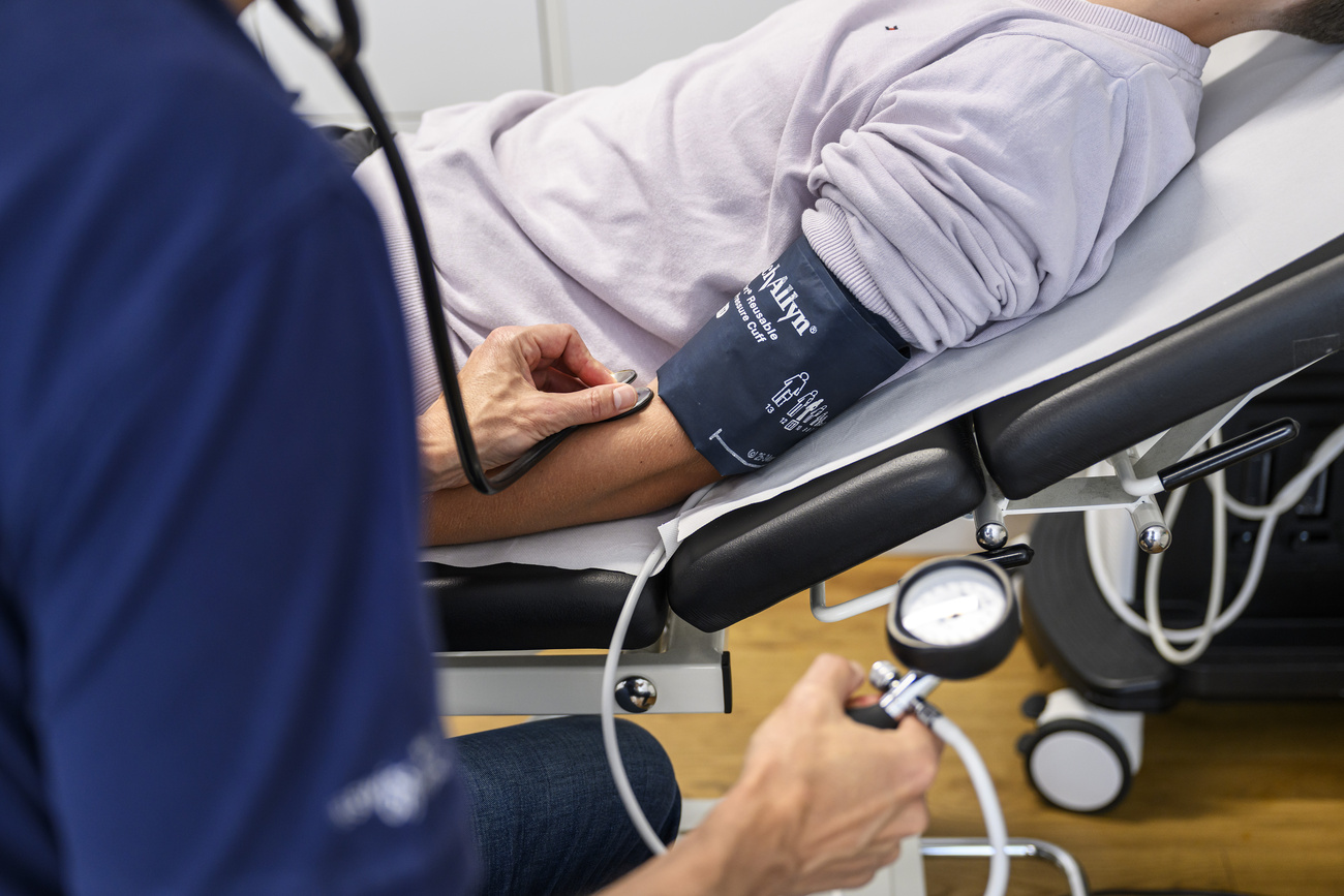 medico misura la pressione a un paziente