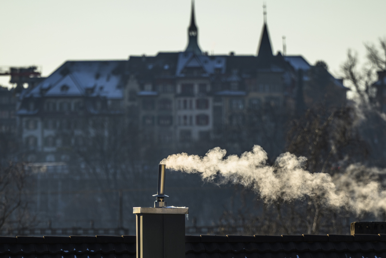 fumo esce da ciminiera su un tetto.