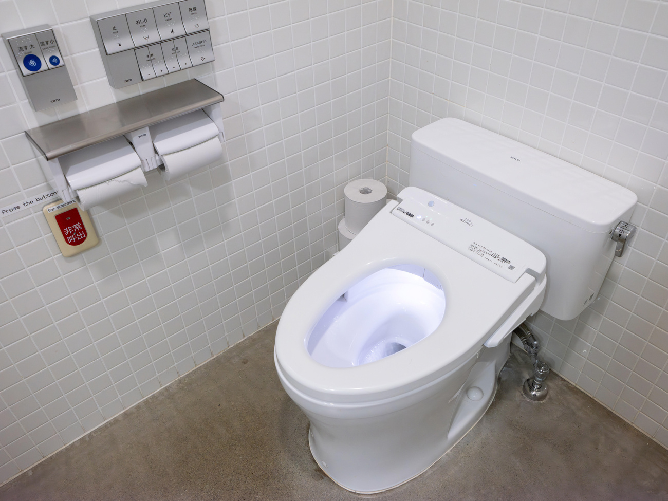 A modern toilet in Japan with remote controls for flushing (blue buttons) and other functions