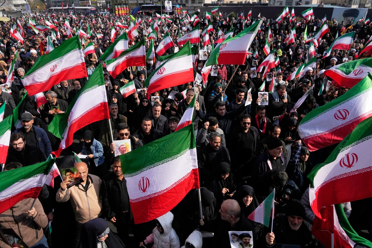 Une foule brandissant des drapeaux iraniens