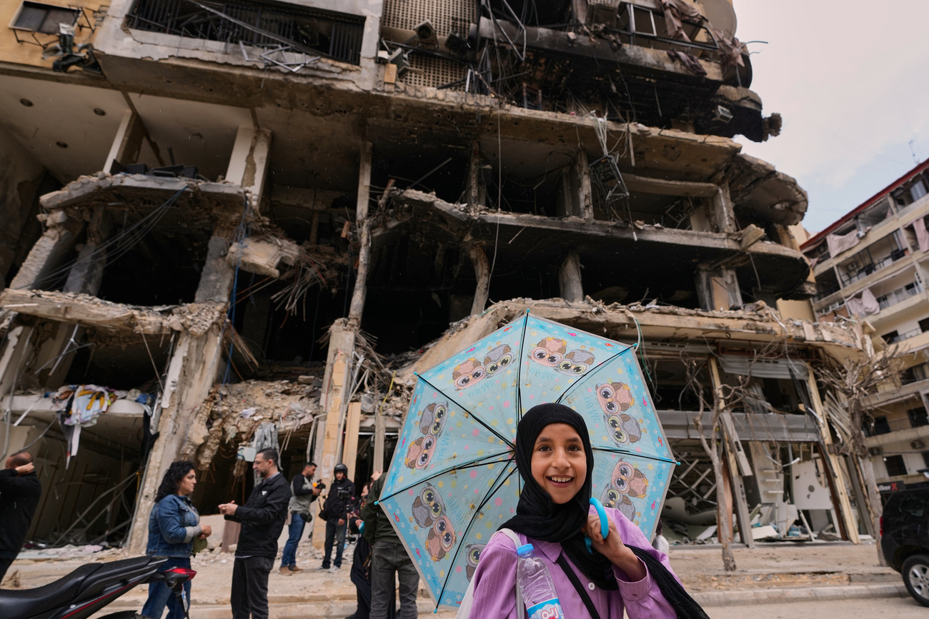 A girl passes in front of a destroyed building, following a ceasefire between Hezbollah and Israel in Dahiyeh, Beirut's southern suburbs, Lebanon, Monday, April 20, 2026. (AP Photo/Hussein Malla)