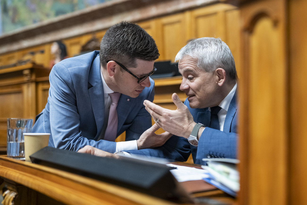 Il portavoce della commissione delle istituzioni politiche Simone Gianini discute con il consigliere federale Beat Jans durante il dibattito sull'Iniziativa per la democrazia.