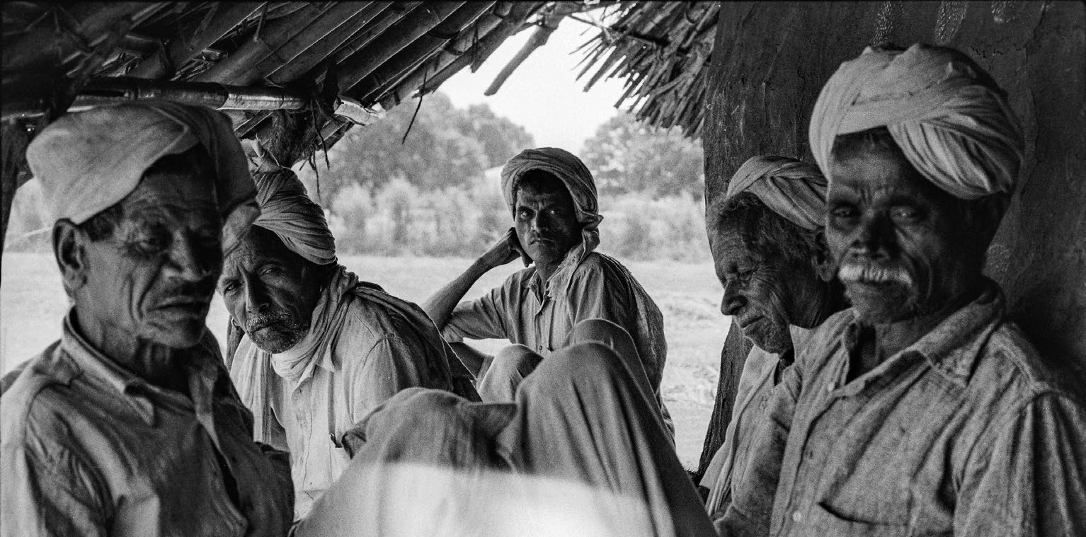 A black-and-white photograph of a group of men wearing headgear