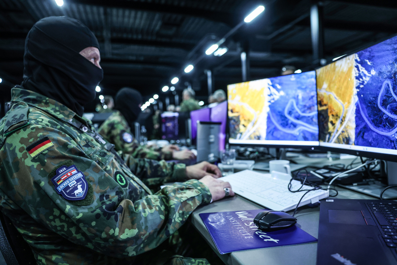 Soldiers and IT experts sit in front of screens during NATO's Locked Shields cyber defence exercise