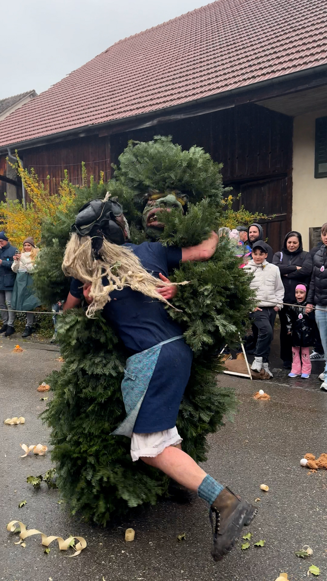 A man dressed in a holly costume is wrestling with a man dressed as an elderly man.