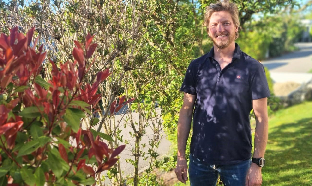 Swiss man standing in his garden in the canton of Fribourg, Switzerland.