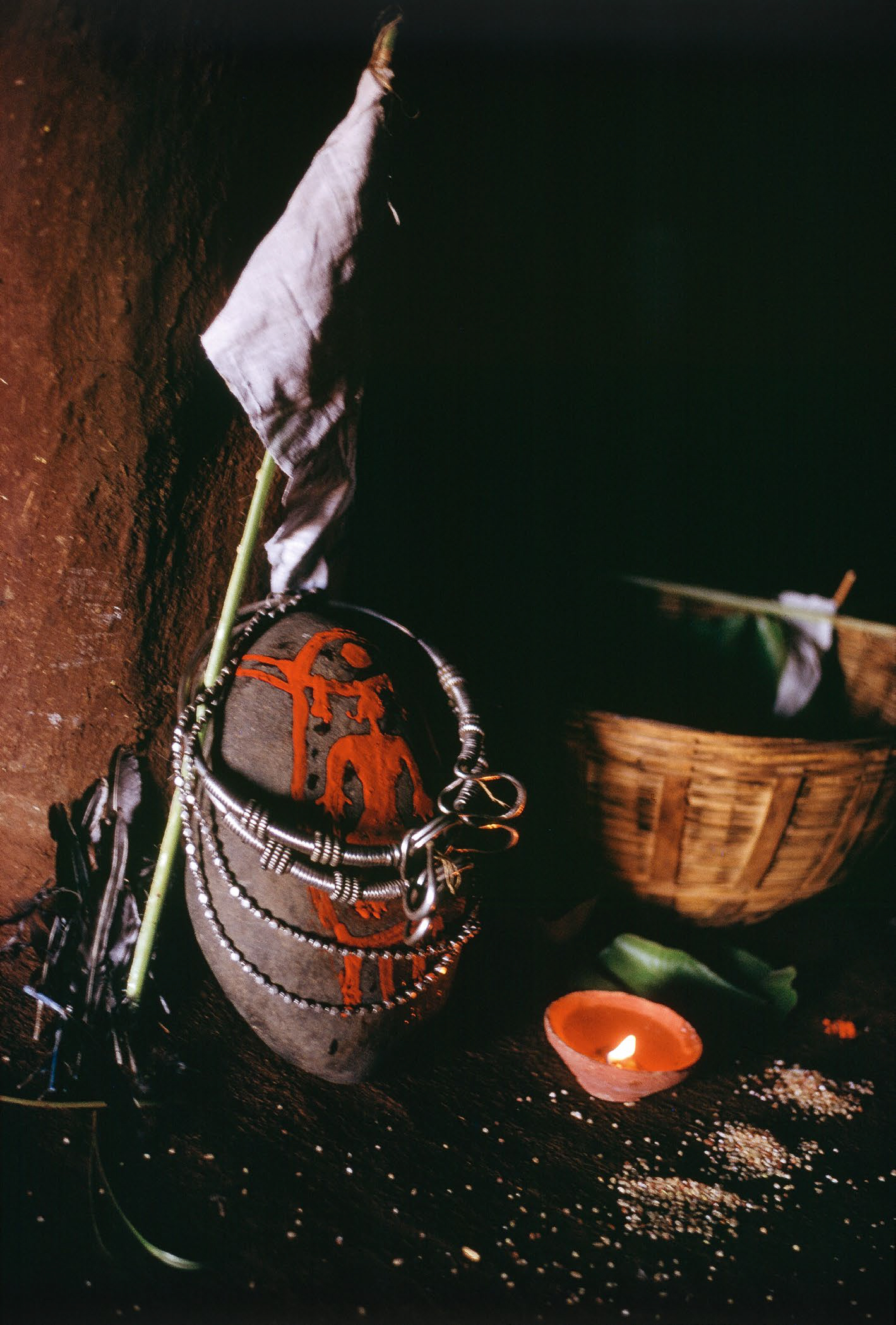 A stone with a design and decoration on it, with a candle next to it.