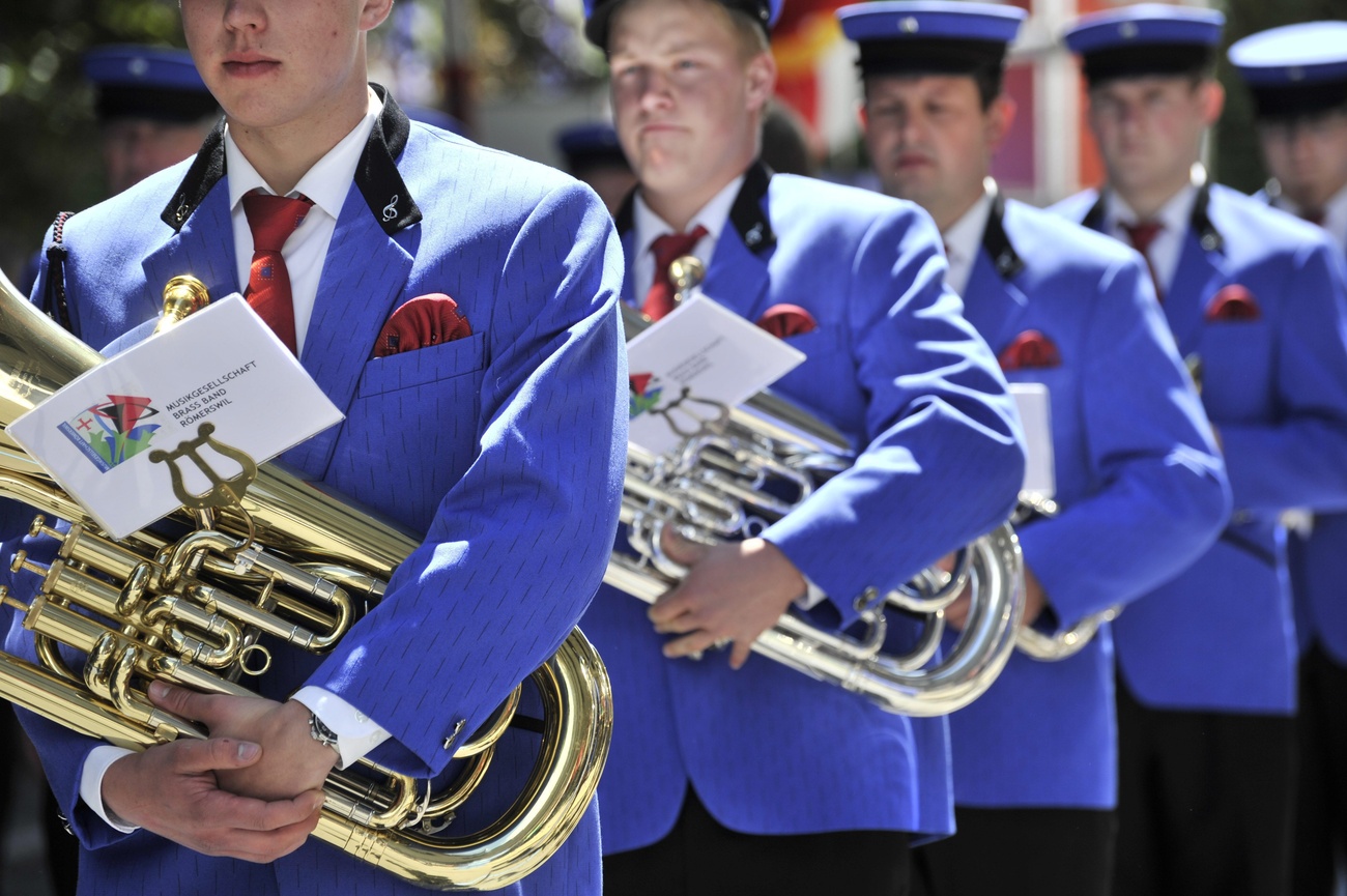 Mitglieder einer Brass Band in blauer Uniform, aufgereiht bei einer Veranstaltung im Freien