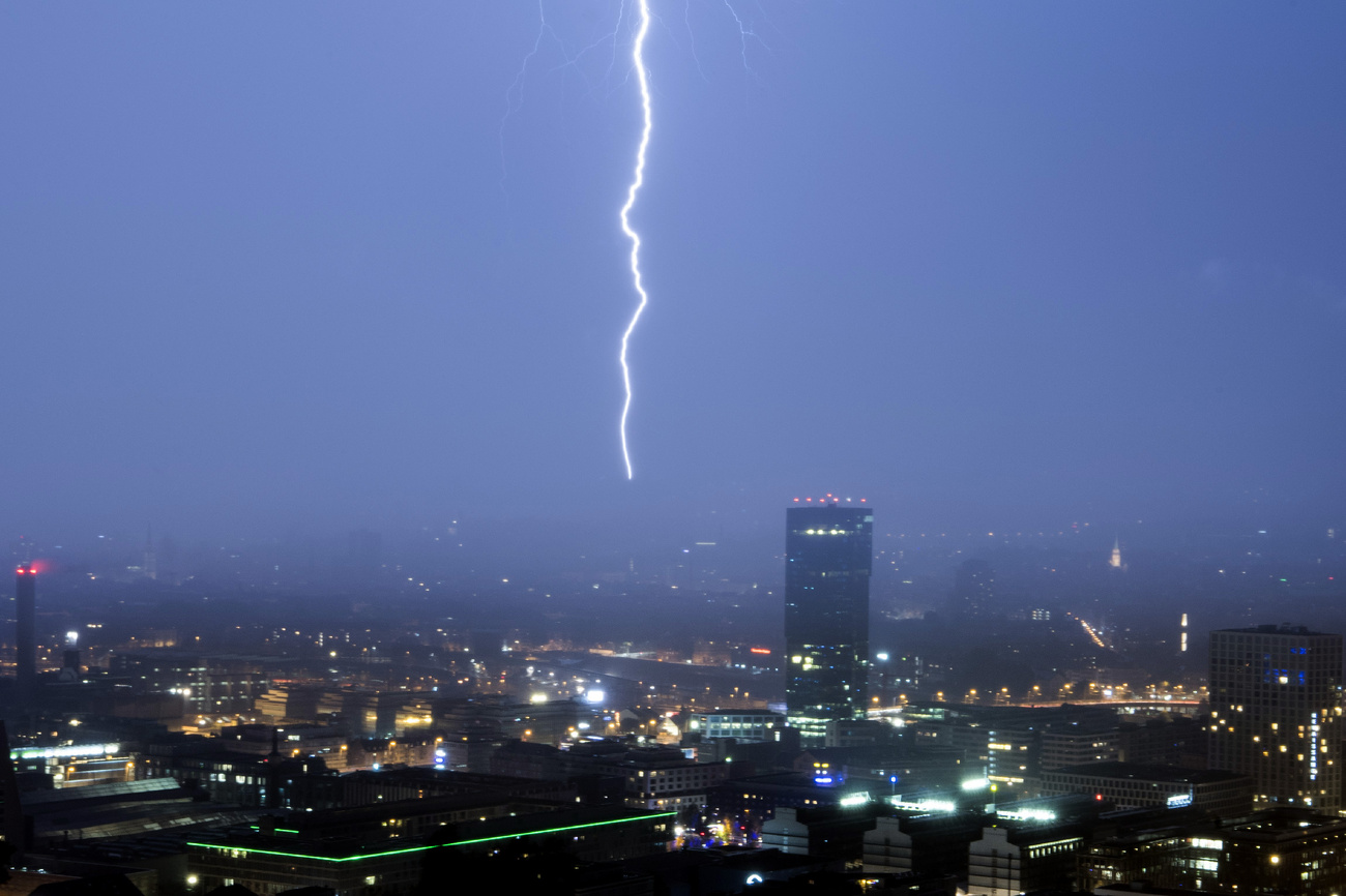 Blick auf Zürich in einer Gewitternacht, in der Mitte ein Blitz