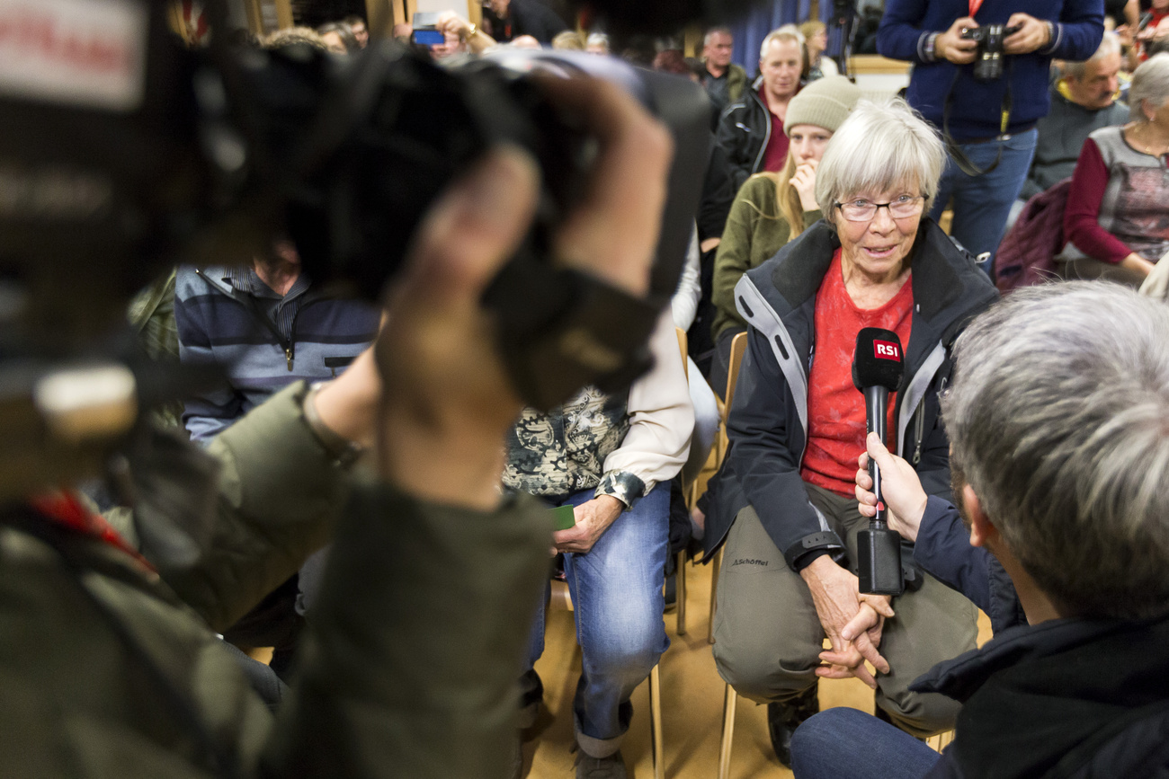 Un'abitante di Albinen viene intervistata durante l'assemblea comunale, un tema classico del giornalismo locale, che segue da vicino le decisioni politiche prese in loco.