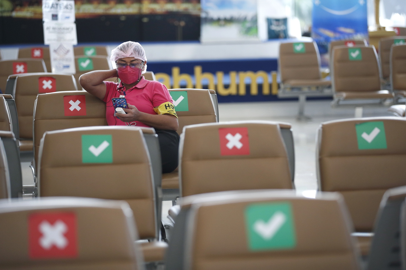 A designated hotel worker waits for arriving visitors at Suvarnabhumi Airport, Samut Prakan province, Thailand, 01 February 2022.