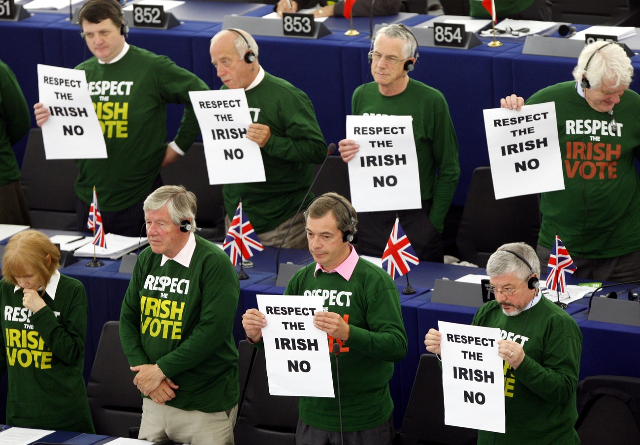 Group of people wearing green shirts reading "RESPECT THE IRISH VOTE" holding signs saying "RESPECT THE IRISH NO"