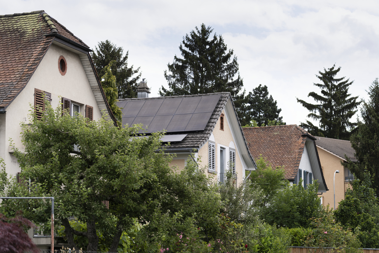 Detached houses, one of which has a solar panel system on the roof