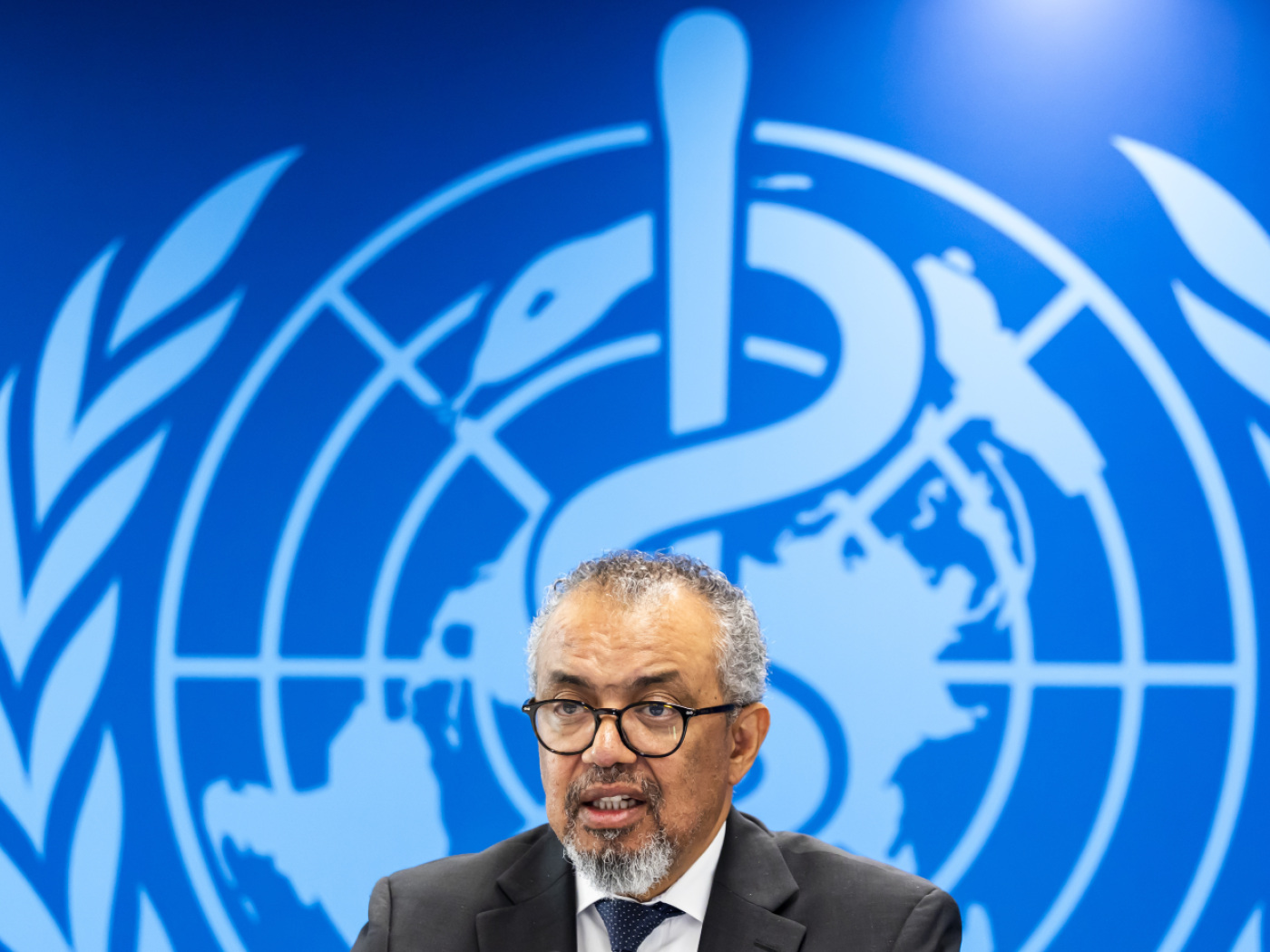 Photo of Director-General Tedros Adhanom Ghebreyesus in front of WHO logo